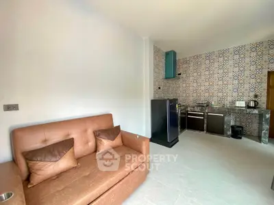 Modern living room with stylish kitchen featuring patterned tiles and sleek appliances.