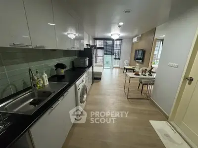 Modern open-layout kitchen with washing machine and dining area leading to a balcony.