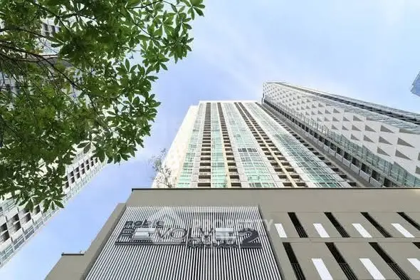 Stunning modern high-rise building with sleek architectural design and lush greenery.