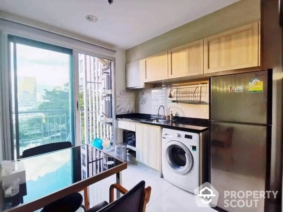 Modern kitchen with washing machine and balcony view in urban apartment