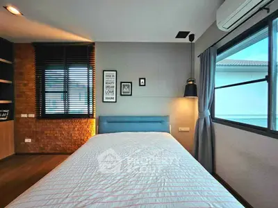 Modern bedroom with stylish decor and large window offering natural light.