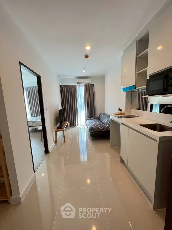 Modern open-plan living room with sleek kitchen and natural light