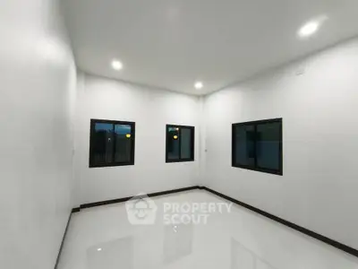 Spacious empty room with large windows and glossy white flooring