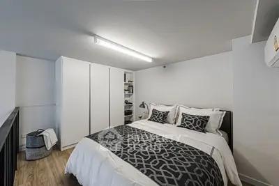 Modern bedroom with stylish bedding and ample storage in a cozy apartment.