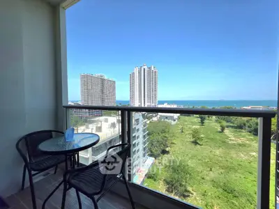 Stunning balcony view of high-rise buildings and ocean, perfect for relaxation.