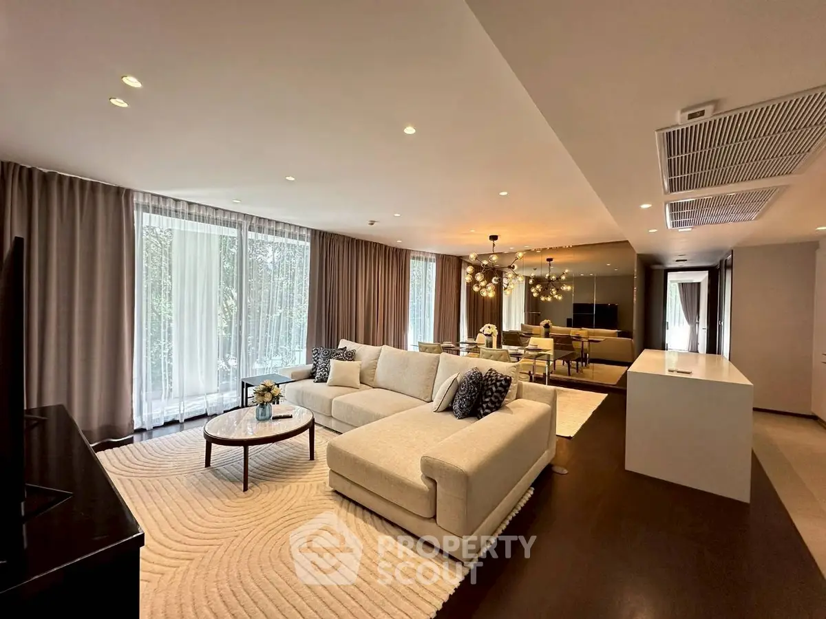 Luxurious modern living room with elegant decor and ample natural light.