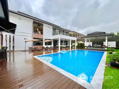 Luxurious modern home with expansive pool and elegant deck, perfect for outdoor entertaining and relaxation.