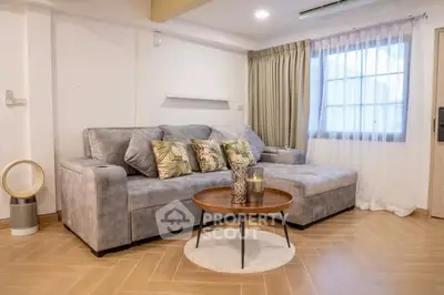 Stylish living room with modern gray sofa and elegant decor in a cozy apartment.
