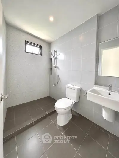 Modern minimalist bathroom with sleek fixtures and neutral tiles.