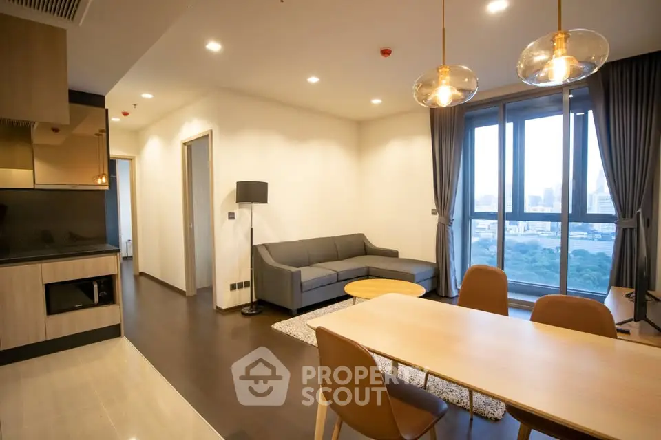 Modern living room with city view, stylish furniture, and open layout in a high-rise apartment.