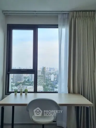 Modern study area with city view from high-rise apartment window.