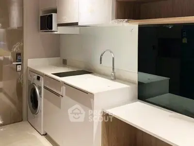Modern kitchen with sleek white cabinetry and built-in appliances in a compact layout.