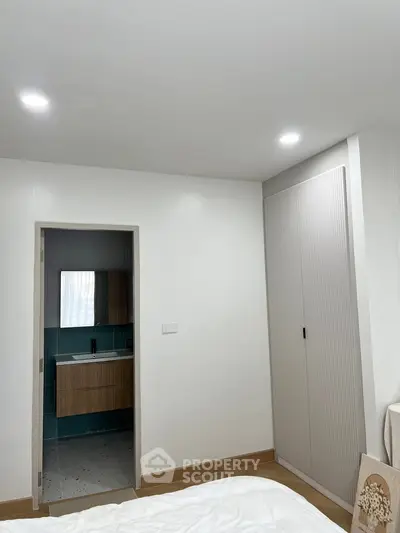 Modern bedroom with ensuite bathroom and sleek wardrobe design.