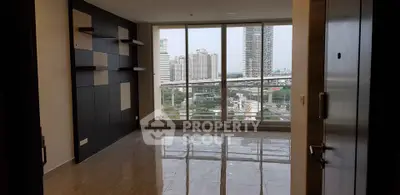 Spacious modern living room with large windows offering stunning city views in a high-rise apartment.