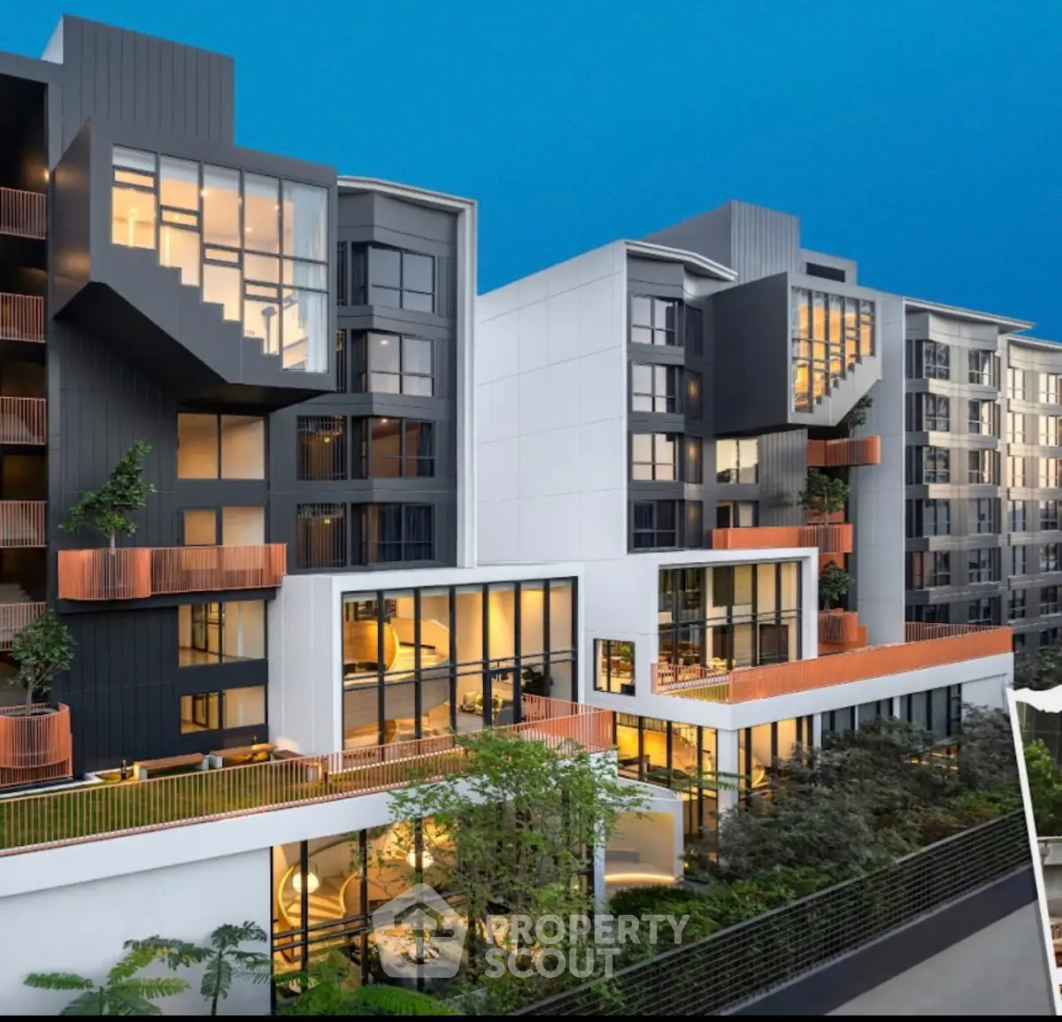 Modern apartment building with large windows and balconies, showcasing contemporary architecture and lush greenery.