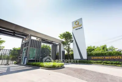 Modern entrance of Q District Westgate with sleek design and lush greenery.