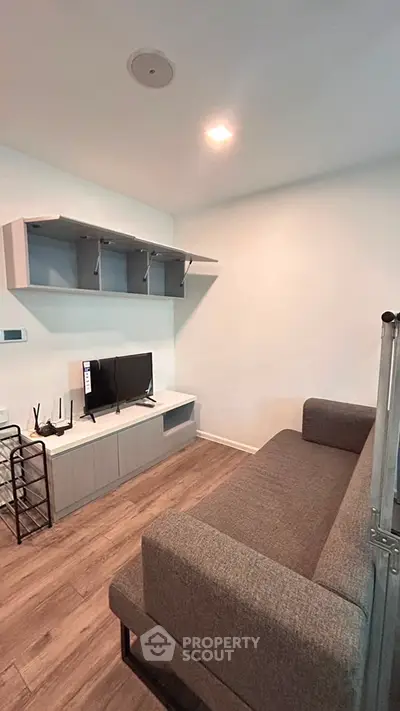 Modern living room with sleek furniture and mounted shelves, perfect for cozy urban living.