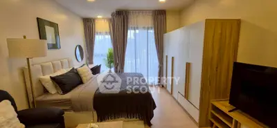 Modern bedroom with stylish decor, large window, and cozy ambiance