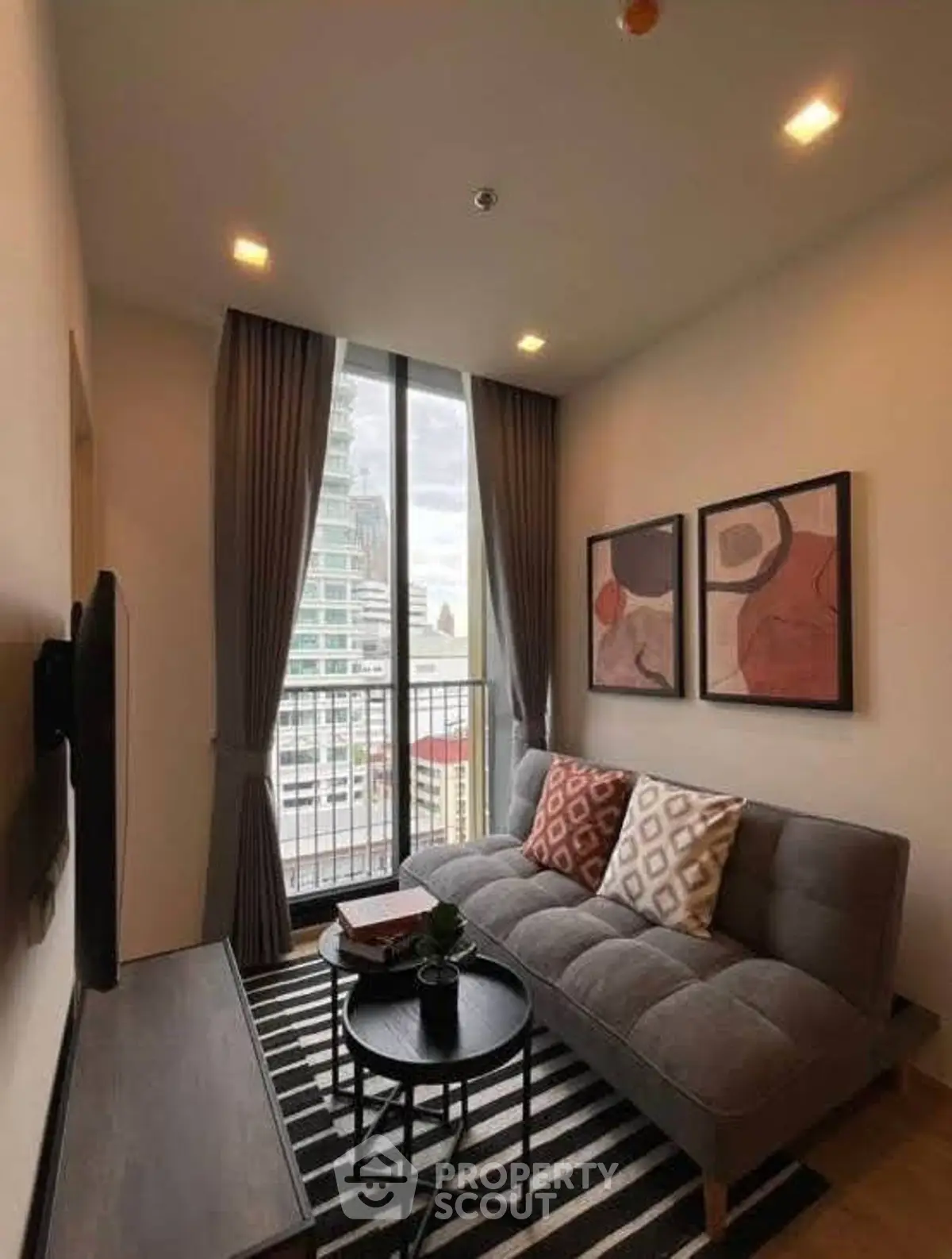 Modern living room with stylish decor and city view from large window.
