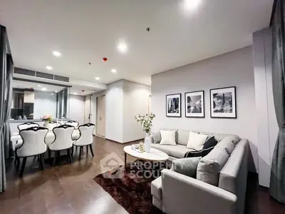 Elegant living room with modern decor and dining area, featuring stylish furniture and ambient lighting.