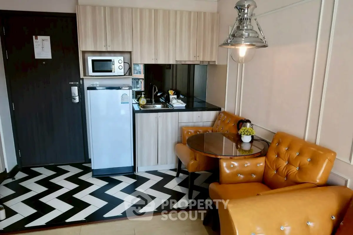 Chic modern kitchen with stylish chevron flooring and cozy seating area.