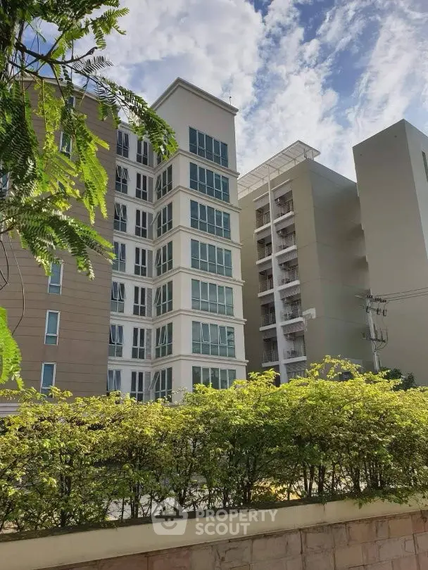 Modern apartment building with lush greenery and clear blue sky