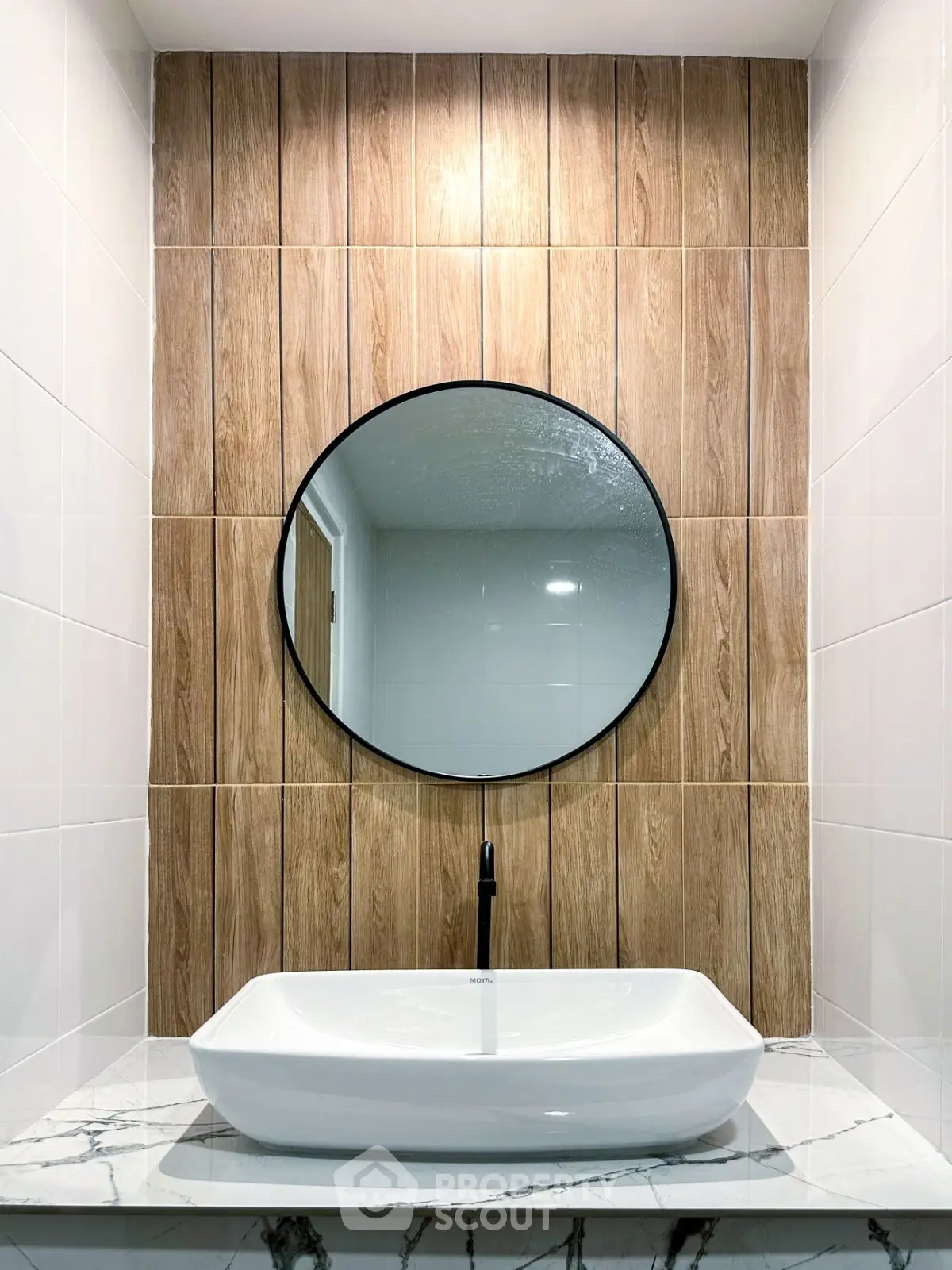 Modern bathroom with stylish round mirror and elegant sink