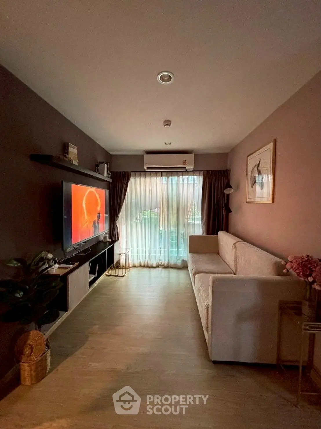 Cozy living room with modern decor and large TV, perfect for relaxation.