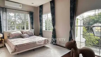 Luxurious bedroom with large windows and elegant decor in a modern home.