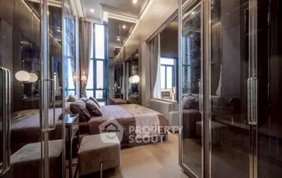 Luxurious bedroom with mirrored walls and elegant decor in a modern apartment.