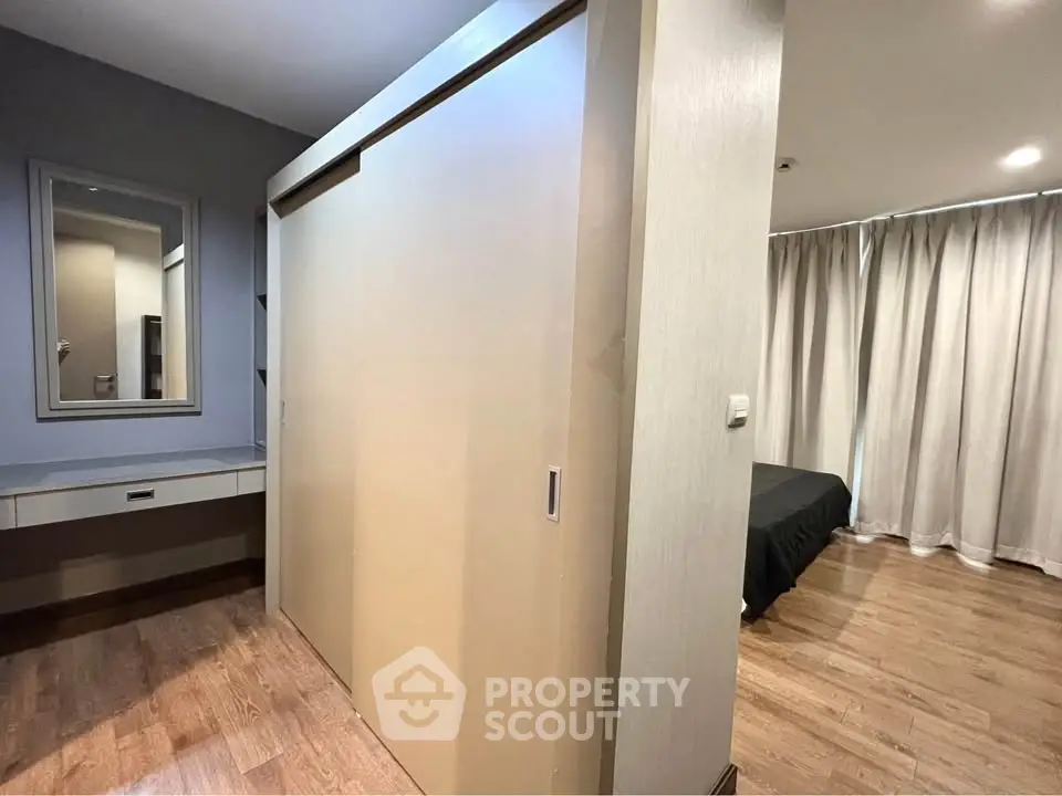 Spacious bedroom with wooden flooring and sliding closet doors in modern apartment.