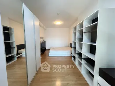 Spacious bedroom with modern shelving and mirrored wardrobe