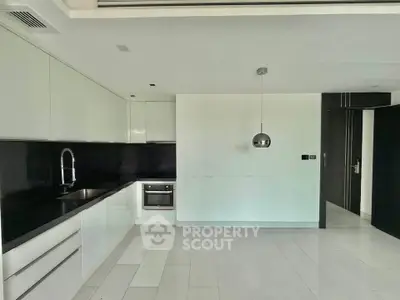 Modern kitchen with sleek white cabinetry and built-in oven in a contemporary apartment.