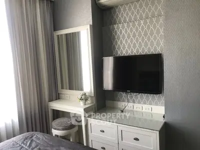 Chic bedroom with elegant wallpaper, TV, and vanity set, perfect for modern living.