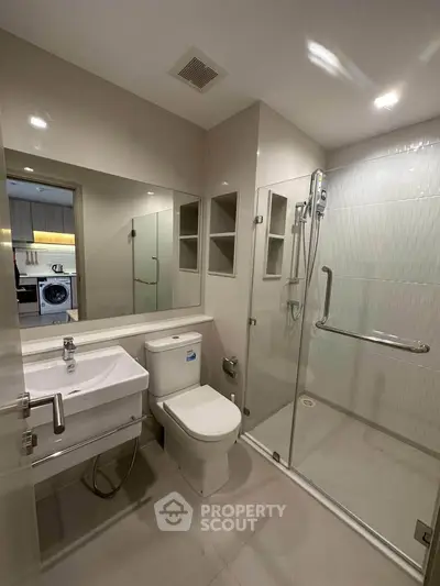 Modern bathroom with glass shower and sleek fixtures in a contemporary apartment.