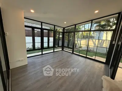 Spacious modern living room with large windows and garden view, perfect for natural light lovers.