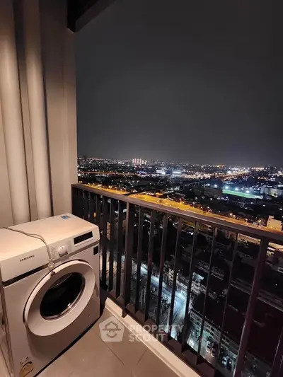 Stunning high-rise balcony view with city lights and modern washing machine.