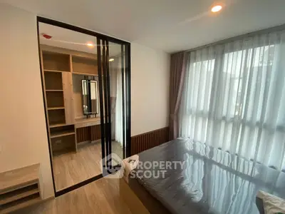 Modern bedroom with large window and built-in closet in stylish apartment