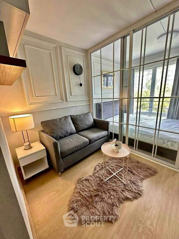 Chic modern living room with cozy sofa, stylish decor, and large mirrored wardrobe in urban apartment.