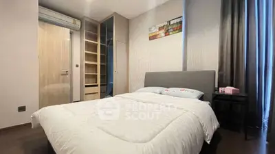 Modern bedroom with cozy bed and built-in wardrobe in stylish apartment.