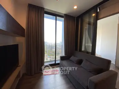 Cozy living room with a balcony view, featuring a comfortable sofa and modern decor.