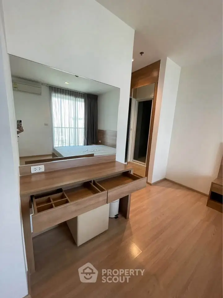 Modern bedroom with wooden flooring and built-in vanity mirror