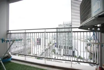 High-rise balcony with city view and air conditioning unit
