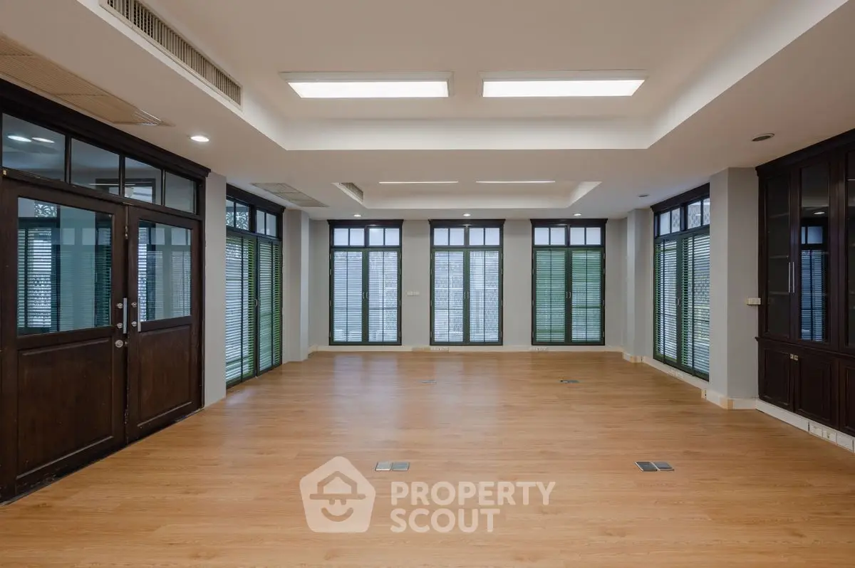 Spacious modern living room with wooden flooring and large windows