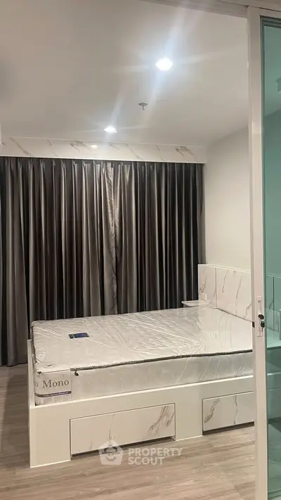Modern bedroom with sleek design and floor-to-ceiling curtains in a stylish apartment.