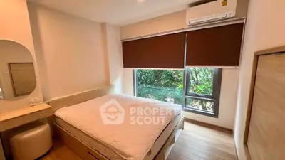 Cozy bedroom with large window and modern furnishings in a serene setting.