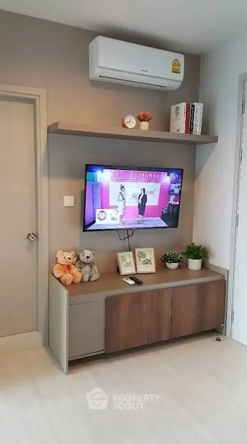 Modern living room with wall-mounted TV and stylish shelving unit.