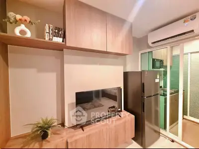 Modern living room with sleek wooden cabinets, flat-screen TV, and stainless steel fridge in cozy apartment.