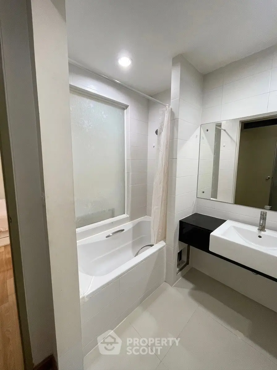 Modern bathroom with sleek design featuring a bathtub and stylish sink area.