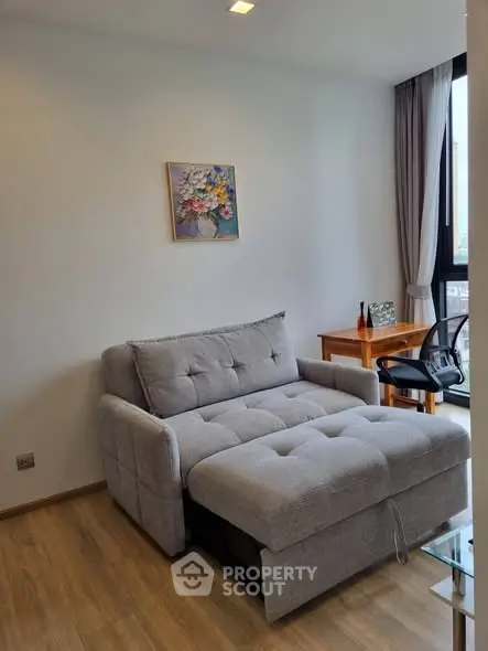 Cozy living room with modern sofa bed and work desk, perfect for urban living.
